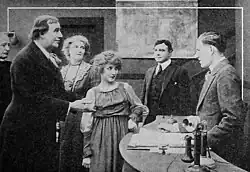 Black and white film still showing three people in period costume