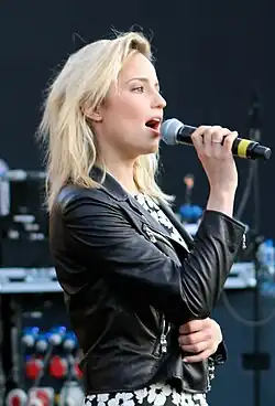 Dianna Agron singing, wearing a black leather jacket