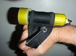 Small dive light on soft Goodman type handle, side view, showing use of handle