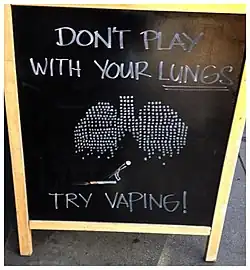 A sign outside of a vape shop suggesting vaping is safer than smoking.