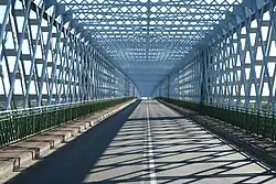 A two-lane road caged in intertwined steal bars, in a style reminiscent of the Eiffel tower.
