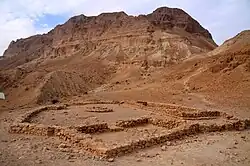 Excavated temple of Ein Gedi with background of modern Kibbutz and Dead Sea.