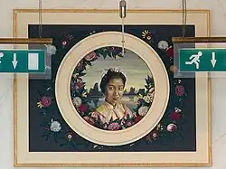 A portrait of a woman above an emergency escape door