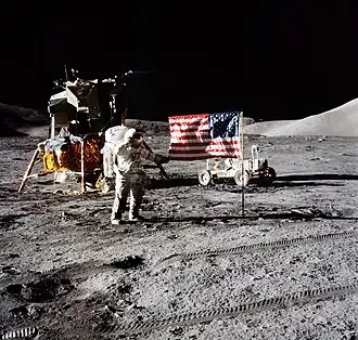The first image is a successful moon landing in full color containing the American flag, an astronaut, a lunar rover, and a lunar landing module. The second image is an emblem containing a statue of the Greek god Apollo, red stripes inside an eagle made of white lines, the Moon, Saturn, and a spiral galaxy; along the outside of the emblem are is the word "Apollo" along with the number "seventeen" in roman numerals, and then the name "Cernan," "Evans," and "Schmitt." The third and final image contains Schmitt on the left, Cernan in the middle and sitting, and Evans behind Cernan.