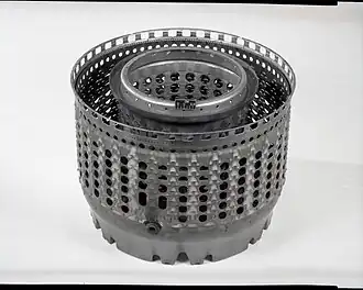 J85 annular combustor, displayed rear-end up. When installed in the engine this open end is closed by the first stage turbine nozzle vane ring the flow area of which (together with the area of the exhaust nozzle) back pressures the compressor to control its pressure rise and flow rate as shown on a compressor map.