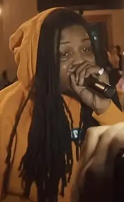 FBG Duck wearing a orange hoodie, during performance