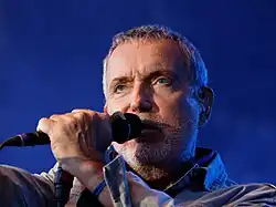 Gray-haired man with a microphone.