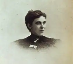 B&W portrait photo of a young woman with her hair in an up-do wearing a dark blouse.
