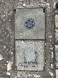 A Fukow 18 tag on a manhole cover in Mirów, Warsaw