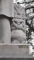 The statue's Māori carving and creator's signature