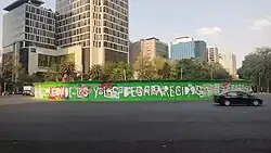 A dry tree lies behind many fences with Christmas decorations.
