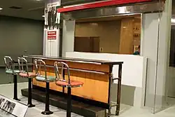 Lunch counter with four barstool height seats, as part of a museum exhibit
