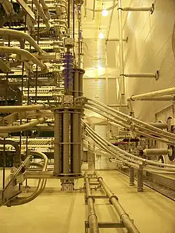 A yellow-tinted room with wires and other metallic structures.