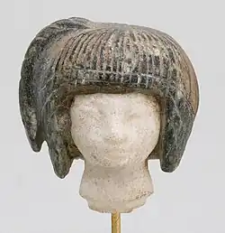 Head from a spoon in the form of a swimming girl; 1390–1353&nbsp;BC; travertine (the head) and steatite (the hair); 2.8 × 2.7&nbsp;cm; Metropolitan Museum of Art