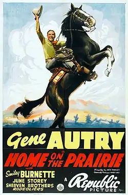 A poster featuring a painting of a black horse rearing on its hind legs as a man dressed as a cowboy riding on its back raises his hat.