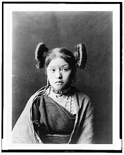 Hopi girl at Walpi, c. 1900, with squash blossom hairstyle indicative of her eligibility for courtship, the squash flower being a symbol of fertility.