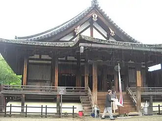Lower shutters from central three bays (inter-pillar spaces) have been lifted out and stacked against the outermost bays