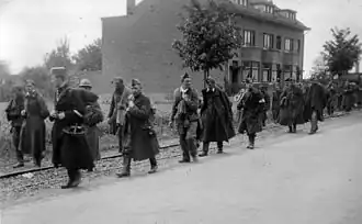 Belgian soldiers taken prisoner by the Germans marching down a road