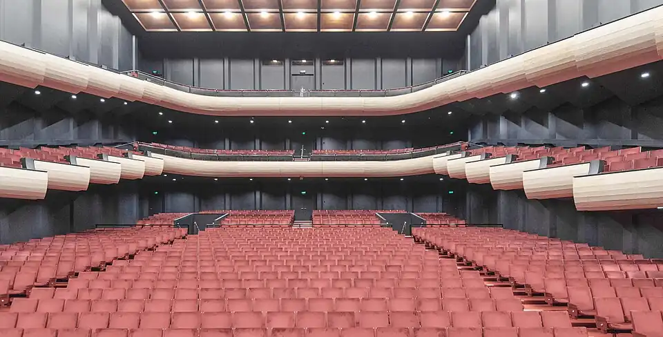 Rows of seats in the audience seating area, and balcony seats on the sides and back.