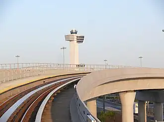 JFK Airport's control tower in the background and an AirTrain guideway in the foreground