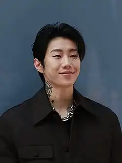 Jay Park smiling in a black dress