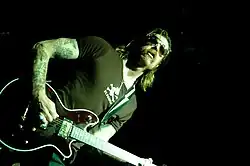 Photo of Jesse Hughes playing a guitar