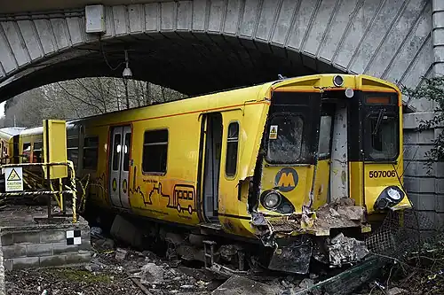 An image of the train, after having crashed through the passenger walkway, with damage to its front