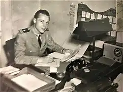 Naval officer in uniform sitting behind a desk and working