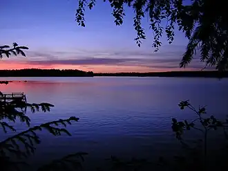 A lake surrounded by trees at sunset