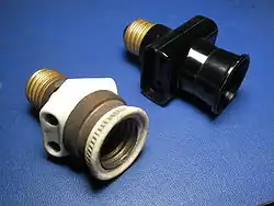 Italian bypass lampholder plugs with Edison screw mount. Left: early type (porcelain and brass, c. 1930). Right: late type (black plastic, c. 1970)