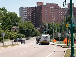 A high-rise hospital building viewed from a wide boulevard
