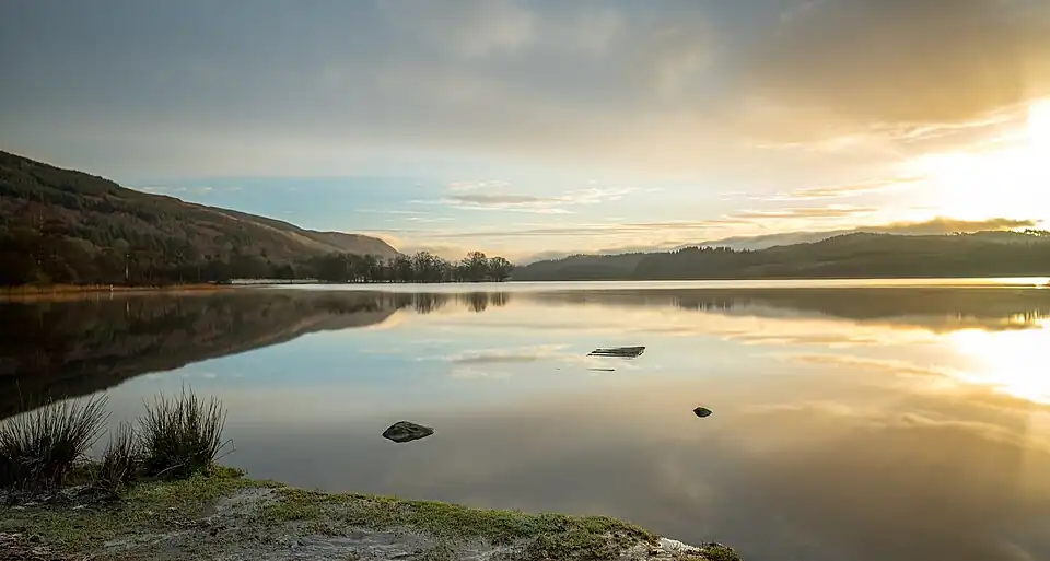 Sunrise over Loch Ard showing its crystal clear water