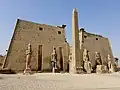 Entrance of the Luxor Temple, western façade; a pair of obelisks usually stood in front of a pylon; the 2nd obelisk (the Luxor Obelisk, 23 metres (75&nbsp;ft) high, not shown) was moved in the 1830s to the Place de la Concorde in France.