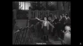 Lyubov Orlova character screams "Follow Me" (За мной!) in Volga-Volga (1938). Despite rumors, it has no direct connection to The Motherland Calls monument apart from the propaganda poster "Fascism is the most vicious enemy of women. All rise to fight fascism!",[58] as according to the official Soviet art history version.[59] Just like Orlova, as "a symbol of totalitarism", the 1967 statue was also criticised as "an empty and inhuman display of Stalinist kitsch".[60][61]