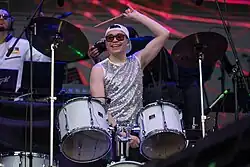 Raymix plays the drums.