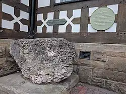 The stone is against the half-timbered wall of Exmewe Hall, on St. Peter's Square, Ruthin.