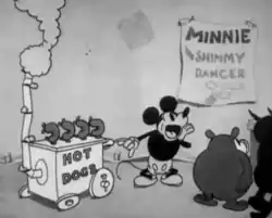 As audiences watch an off-screen dance, Mickey Mouse operates a hot dog stand, calling out to others