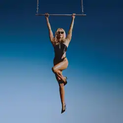 Miley Cyrus wearing a black one-piece swimsuit hanging from a helicopter ladder.
