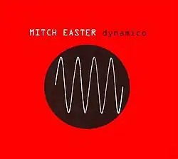 An orange background with a black disc that has a sine wave drawn on it