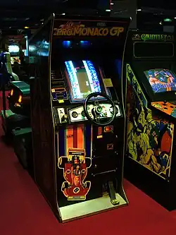 An arcade cabinet with a wheel and a pedal
