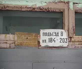 Soviet-style address plaques on the wooden transom of the entrance door of building 1-515 in Moscow