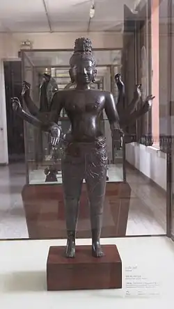 Eight-armed male deity (Maitreya). Provenance Vat Ampil Tok, Kg. Chhnang. 10th century. Bronze with dark patina. Green traces on the feet. H. 75&nbsp;cm. Inv. 2024. National Museum of Cambodia. Phnom Penh.
