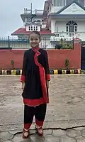 A girl is preparing to go to school in a Newari dress Tapaln