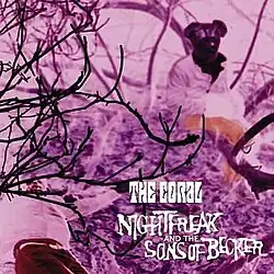 The album art for Nightfreak and the Sons of Becker, depicting two figures sitting on a patch of grass, partially obstructed by branches of a tree