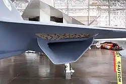 A close up shot of the YF-23's S-duct engine air intake located below the right wing