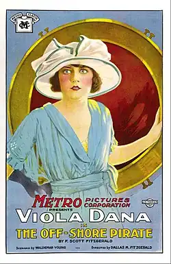 Poster for the 1921 silent film The Off-Shore Pirate. The poster features film actress Viola Dana facing the viewer. She is wearing a white broad-rimmed hat and a powder blue dress. Her right hand is wearing a black glove. Behind her is a large circular mirror with a thick gold trim.