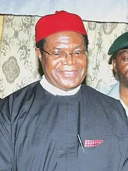 Okwesilieze Nwodo wearing a native cap and eyeglasses