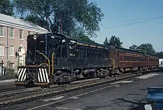 A black locomotive hauling a passenger train