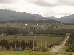 Photograph of the archaeological site of Cochasquí, with pyramidal mounds seen in the distance
