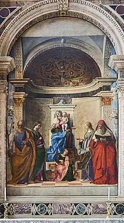 Oil painting. A large altarpiece in which the Madonna sits on a raised throne, with four saints and an angel as described in the article.
